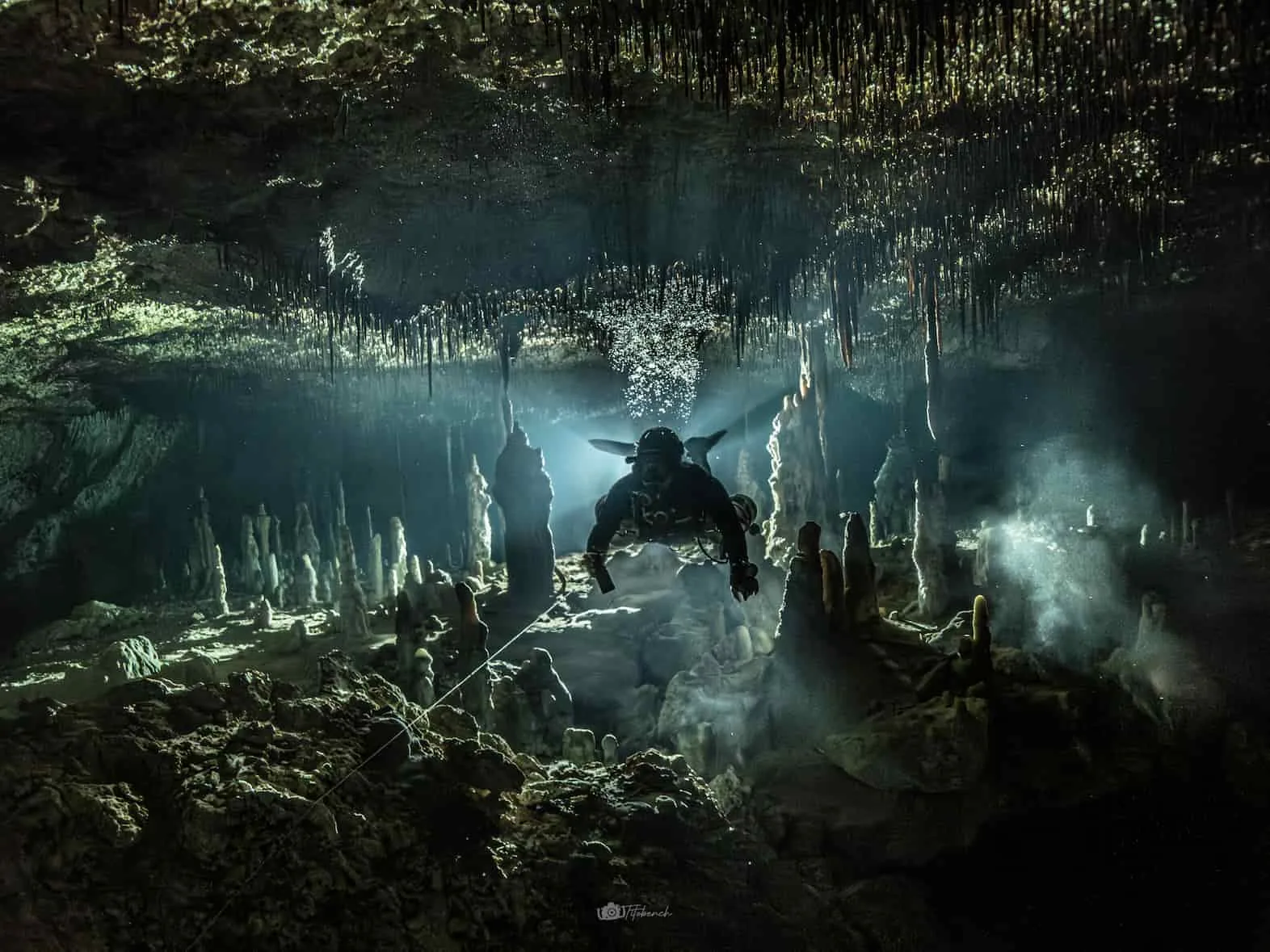 A cave diver among stalactites and stalagmites in Sistema Sac Actun