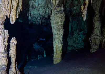 Buzo explorando formaciones de estalactitas y estalagmitas dentro del cenote Dreamgate