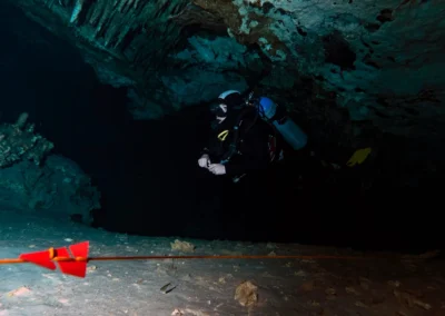 Buzo técnico siguiendo línea guía con flecha de dirección dentro del cenote Dreamgate