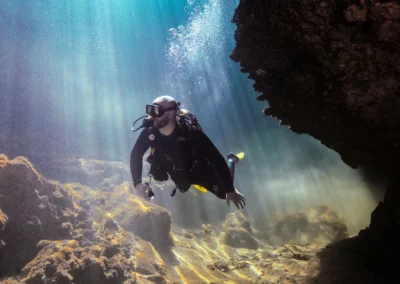 Buzo iluminado por rayos solares dentro de una caverna en Casa Cenote – fotografía de Iván García