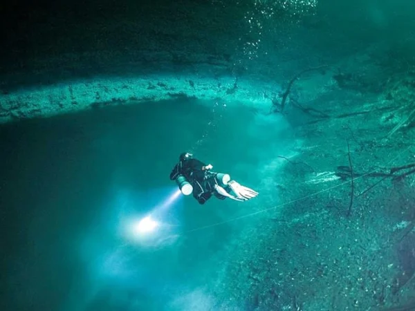 Diver exploring the depths during Orquidea cenote diving, Riviera Maya