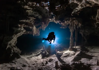 Buzo en el Cenote Dos Ojos descendiendo hacia la Bat Cave, rodeado de formaciones rocosas