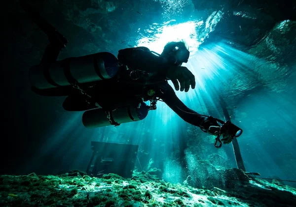 Dreamgate cenote diving with natural light, rock formations, and a technical diver in the Riviera Maya<br> <br> <br>